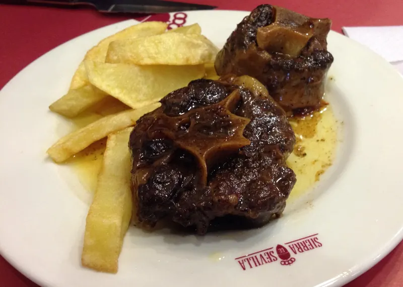 Plato de rabo de toro guisado con patatas fritas